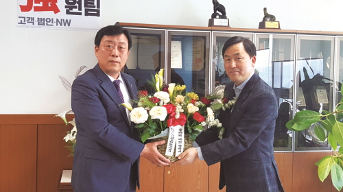 ◇박용석 회장(왼쪽)이 KT강원본부 CS 담당 박관희 상무에게 꽃을 전달하고 있다.