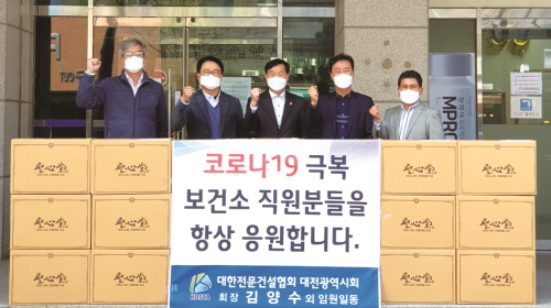 ◇김양수 회장(가운데)을 비롯한 시회 관계자들이 지난 9일 대전 전문건설회관 앞에서 위문품과 함께 기념촬영을 하고 있다.