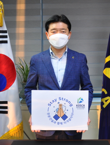 ◇김석 회장이 코로나19 극복 메시지가 담긴 팻말을 들고 ‘스테이 스트롱’ 캠페인에 참여하고 있다.