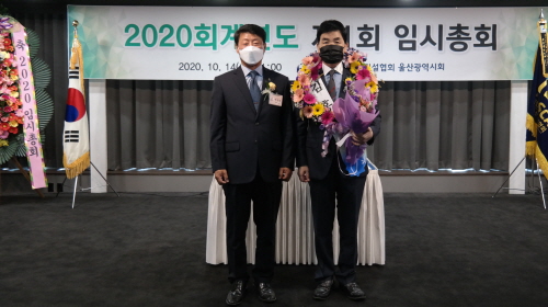 ◇김홍무 회장(오른쪽)이 연임을 확정하고 선거관리위원장으로부토 당선통지서를 받고 있다.