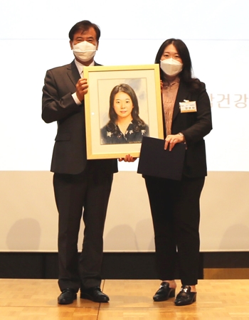 ◇김세원 회장(왼쪽)이 양명화 박사에게 캐리커처를 전달하고 기념촬영을 하고 있다. 